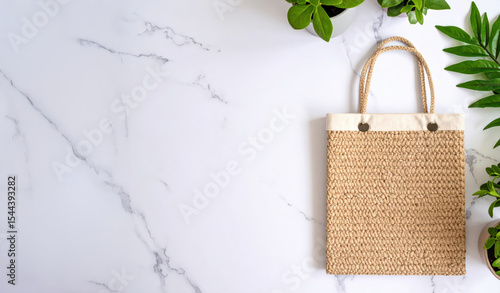 Beige Woven Tote Bag with nature plants on marble Background with copy space