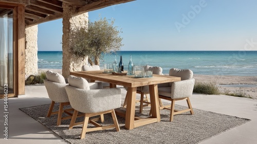 Modern outdoor dining set with teak wood chairs and beige fabric on rug by ocean, white concrete tables with beechwood legs, grey glasses, blue wine bottles, luxury summer style and serene sea view.