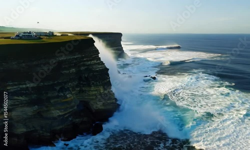 A beautiful ocean view with a cliff in the background. The water is calm and the sky is clear