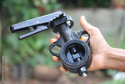 Cast iron butterfly valve held in the hand on natural light