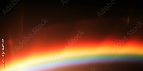 Abstract image showing a blend of warm colors with a dark background and light flare