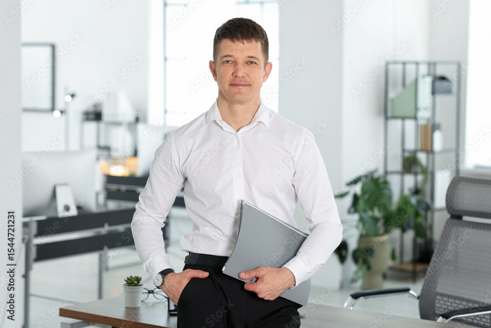 Fototapeta premium Portrait of handsome man with folder in office