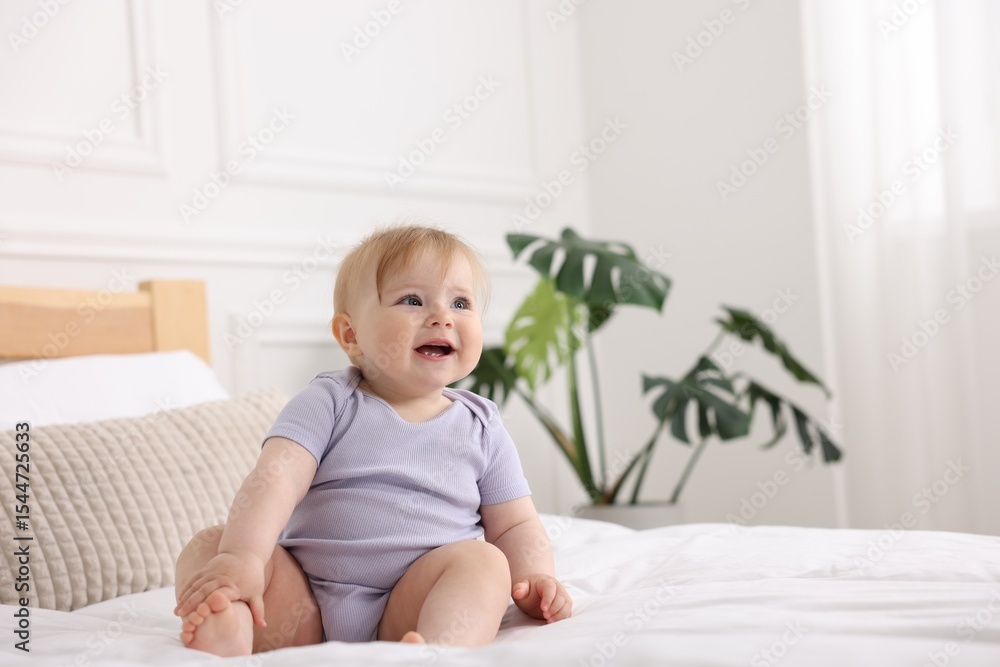 Fototapeta premium Cute little baby on bed at home, space for text