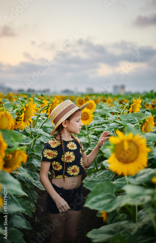 Pretty young girl on the sunflowers field 