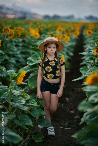Pretty young girl on the sunflowers field 