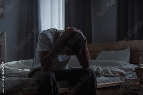 African American man holds head in hands suggesting state of emotional distress