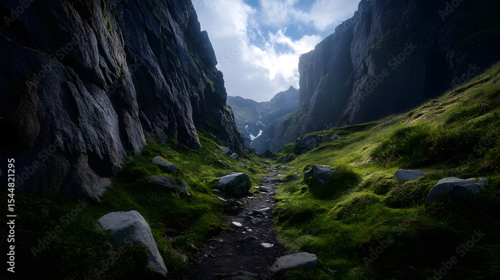 Obraz premium A summer trail that winds through rocky terrain, surrounded by towering cliffs and deep valleys in a mountain range.