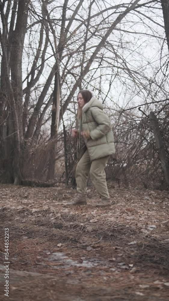 Young woman dancing expressively outdoors in casual winter clothes Young woman dancing expressively outdoors in casual winter clothes