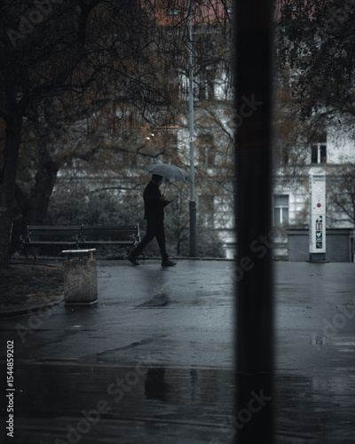 Photography young man walking in the city with umbrella
