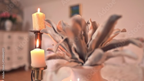 Soft candlelight and natural dried leaf arrangement in rustic Mediterranean home interior with vintage furniture