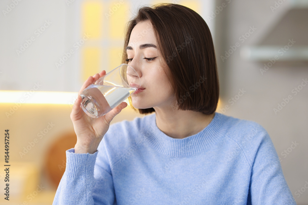 Young woman drinking water from at home Young woman drinking water from at home
