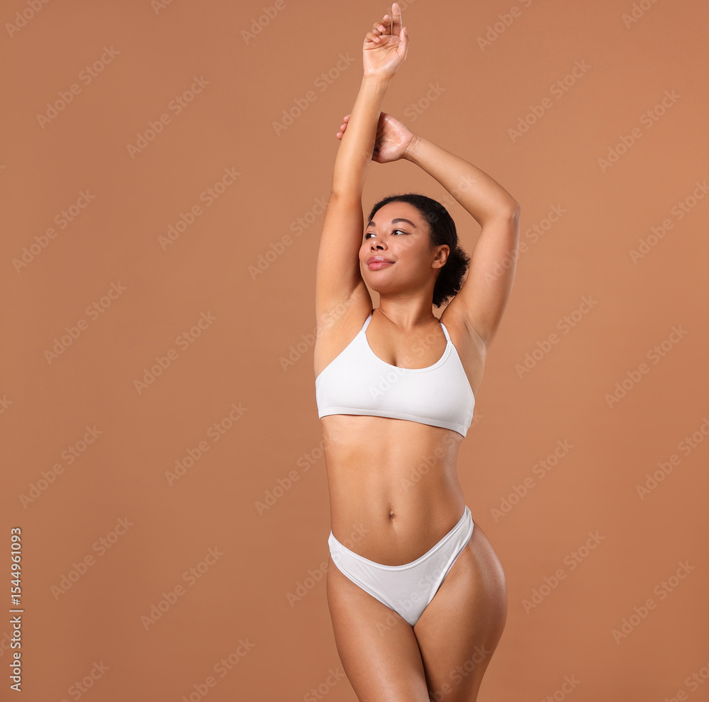 Obraz premium Woman in white underwear with smooth skin after epilation procedure on beige background, space for text