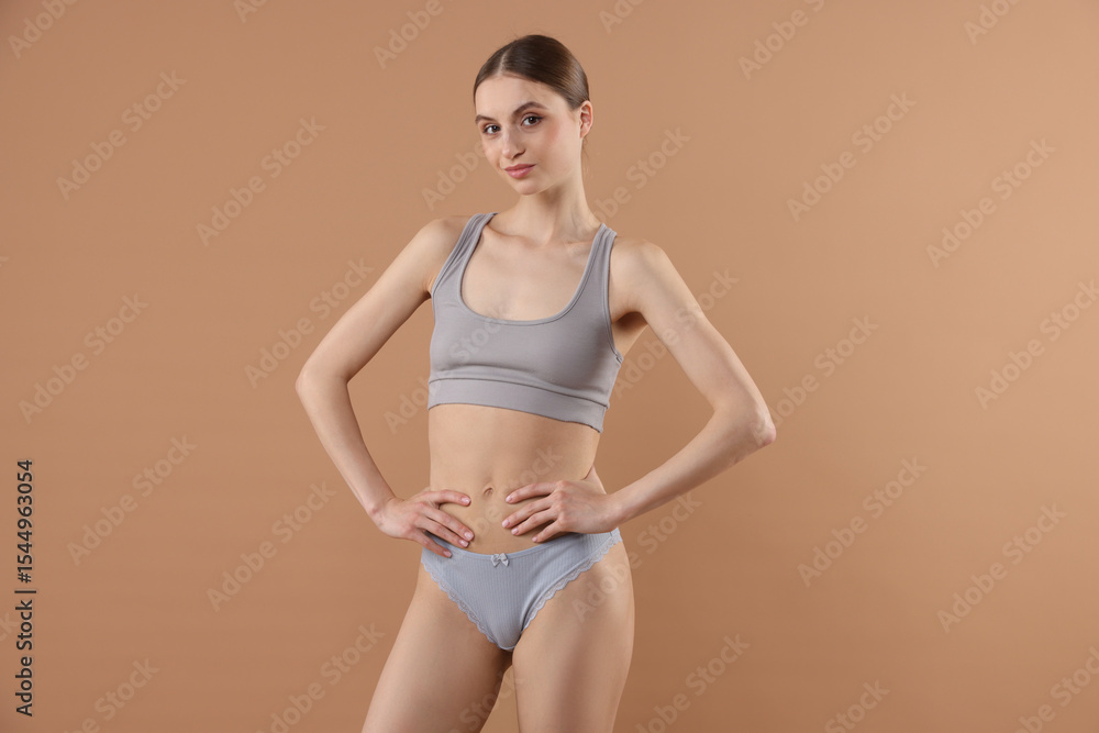 Obraz premium Woman wearing beautiful underwear on dark beige background