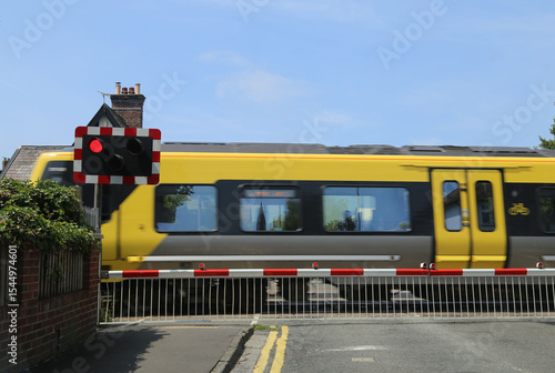 Fotografie A fast moving train at the level crossing in Raven Meols Lane, Formby, Lancashire, England, UK