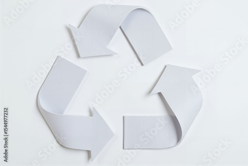 Recycle symbol made of white paper arrows on a light background  