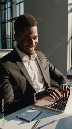 Portrait of happy professional business man company employee, young smiling male businessman entrepreneur or worker looking at camera using laptop computer technology working at corporate office desk.