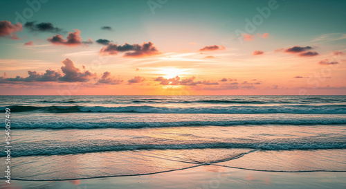 Fototapeta Naklejka Na Ścianę i Meble -  Ocean waves gently rolling onto sandy beach at sunset, pink and orange hues paint the sky, serene and peaceful seascape evokes tranquility and calmness