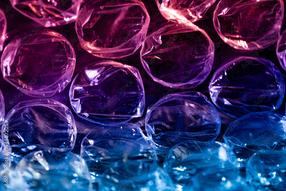 Macro view of bubble wrap in vibrant pink purple and blue lighting showcasing translucent texture Macro view of bubble wrap in vibrant pink purple and blue lighting showcasing translucent texture