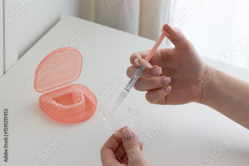 Dental whitening trays and gel applicator on white background