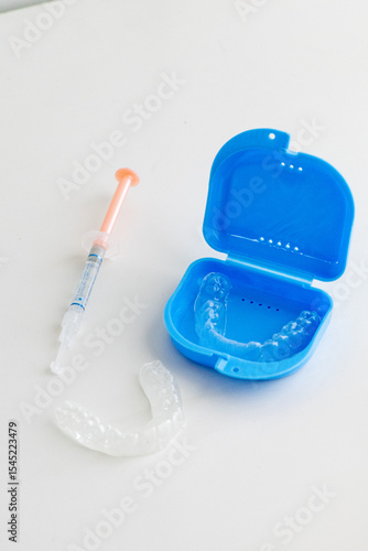 Dental whitening trays and gel applicator on white background