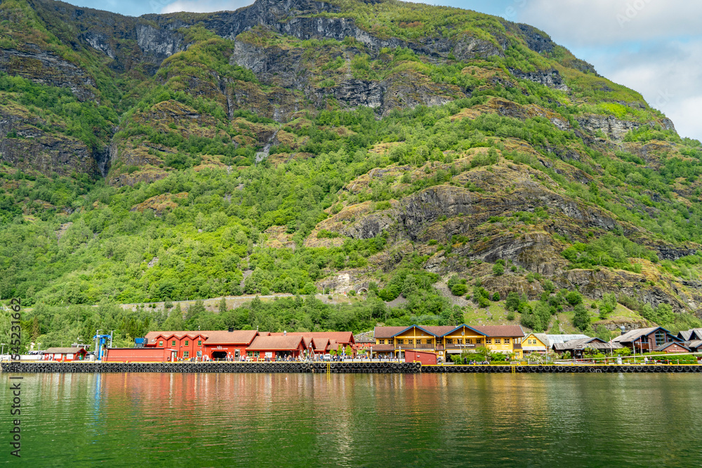 Fototapeta premium Vibrant Flam village buildings line the picturesque fjord waterfront.