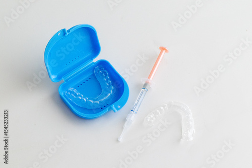 Dental whitening trays and gel applicator on white background