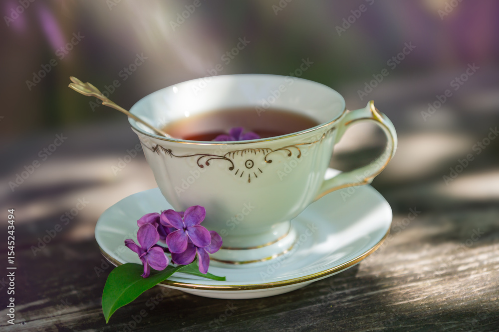 Fototapeta premium A bouquet of lilacs on the table and a cup of tea.
