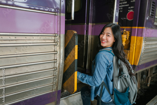 Happy female backpacker boarding train, starting travel adventure