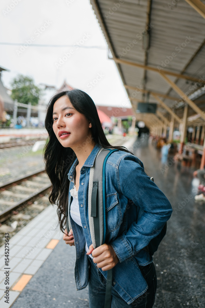Fototapeta premium Tourist with backpack standing on platform waiting for train