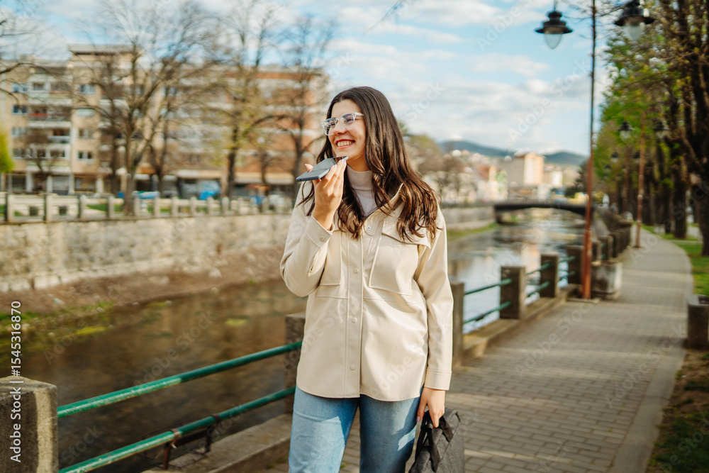 Fototapeta premium Young caucasian woman walk home from work drink coffee and use smartphone 