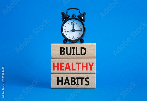 Healthy habits symbol. Concept word Build Healthy habits on wooden blocks with alarm clock. Beautiful blue background. Healthy lifestyle and Healthy habits concept. Copy space