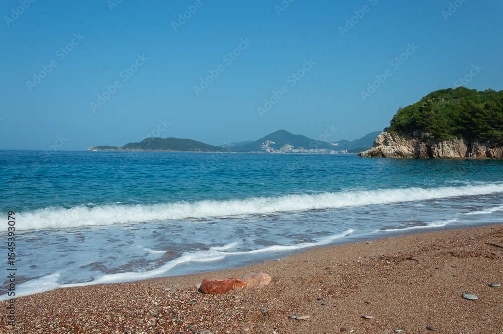 Obraz premium Beach landscape Against the blue sky and azure sea with foam, near Villa Milocer, along the Adriatic coast in Montenegro