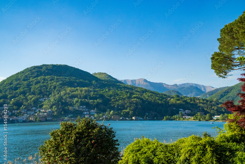 Fototapeta premium Spring view of Lake Lugano in the town of Caslano in the Swiss mountains