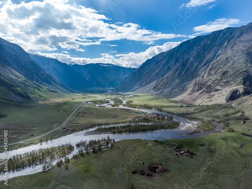 Summer landscape in the Chulyshman mountain valley. Winding mountain river, green alpine meadows and beautiful mountains.