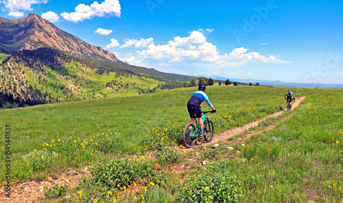 Quadro su tela Mountain bikers on Boulder, Colorado's Springbrook Trail with the Flatirons in t