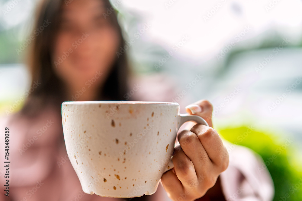 Freelancer holding coffee mug in coffee shop Freelancer holding coffee mug in coffee shop