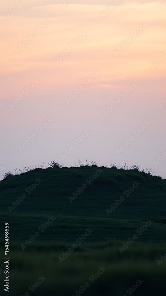 Fototapeta premium Rounded Grassy Knoll at Dusk Under Soft Light vertical