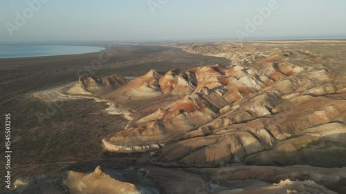 Winding ridges and multi-colored slopes filmed from the air. Aktumsuk's terrain highlights erosion and the memory of the ancient Aral Sea shoreline