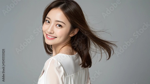 振り返り笑顔を見せる清楚な若い女性
