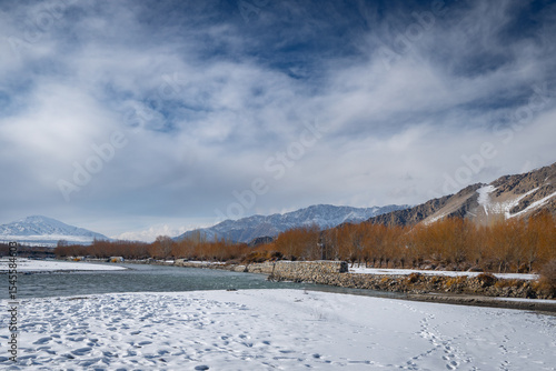 Winter River Landscape in Ladakh with Snowy Banks and Mountains