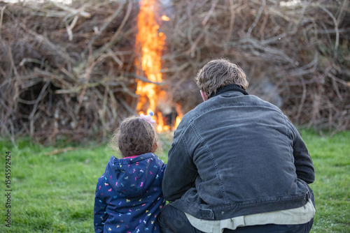 Cuadro en lienzo Father and Doughter looking at Bonfire at Traditional Easter fire event with fla
