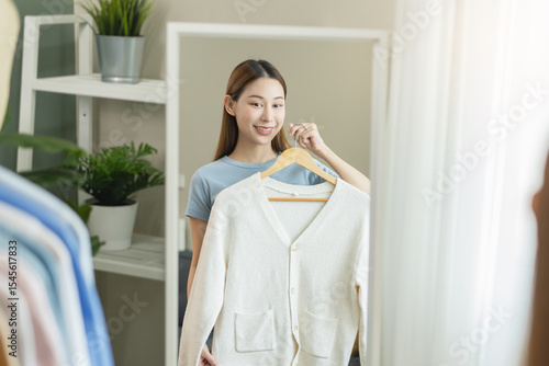 Bild auf Leinwand Young asian women looking at mirror choose outfit before go out at home