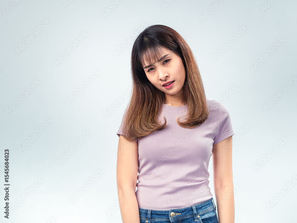 Asian woman in a purple t-shirt looking down with eyes closed, showing a tired or disappointed expression against a plain studio background Asian woman in a purple t-shirt looking down with eyes closed, showing a tired or disappointed expression against a plain studio background