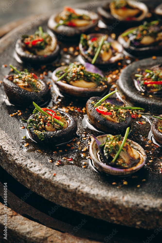 Close up of stuffed mushrooms on a stone plate with chili and green onions Close up of stuffed mushrooms on a stone plate with chili and green onions