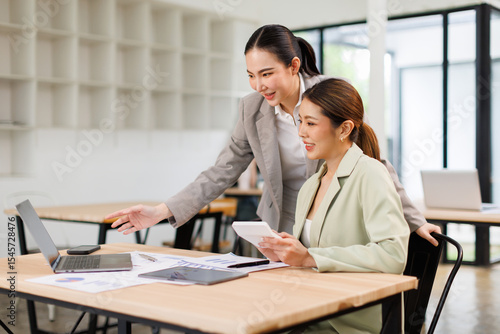 Team of business partnership use calculator to calculate coworkers analysis strategy with discussing a financial planning graph and company budget during a budget meeting in office.
