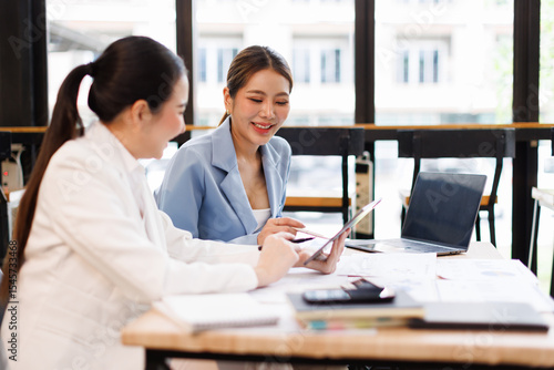 Portrait of Two casual asian business women at work.doing planning analyzing the financial report, business plan investment, finance analysis concept	
