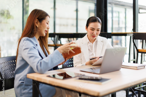 Financial analysts analyze business financial reports on a digital tablet planning investment project during a discussion at a meeting of corporate showing the results of their successful teamwork.	