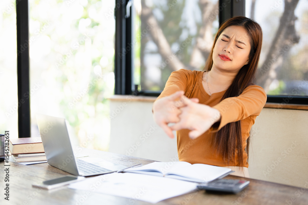 Obraz premium Office asian business woman stretching body for relaxing while working with laptop computer at her desk, office lifestyle, business situation.