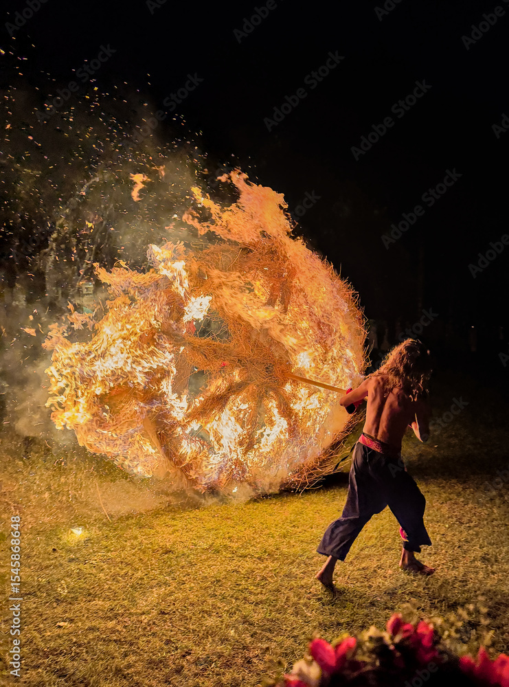Φωτογραφία Man pushes big burning wheel from the hill as Latvian traditional ritual at mids