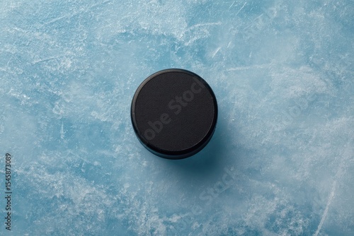 Wallpaper Mural A black puck rests on a light-blue, textured ice surface.  Overhead shot, centered Torontodigital.ca